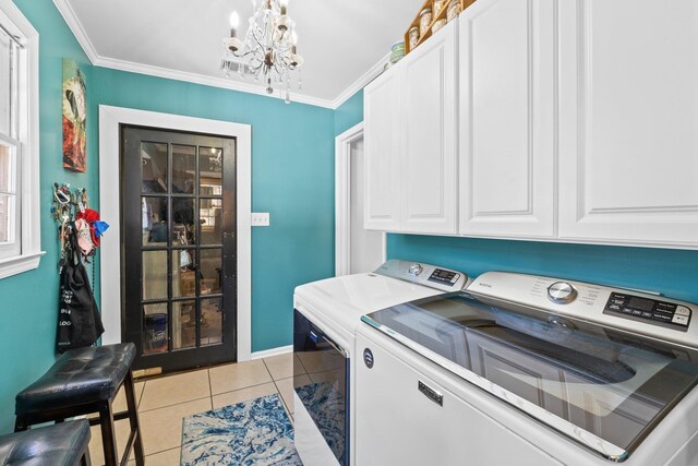 washroom featuring cabinets, washing machine and dryer, ornamental molding, and light tile patterned flooring