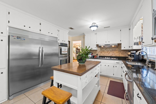 kitchen with white cabinetry, sink, light tile patterned flooring, and appliances with stainless steel finishes