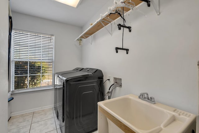 clothes washing area with sink, light tile patterned flooring, and washer and dryer