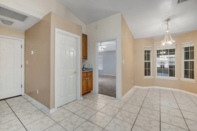 interior space with ceiling fan, light tile patterned floors, plenty of natural light, and vaulted ceiling