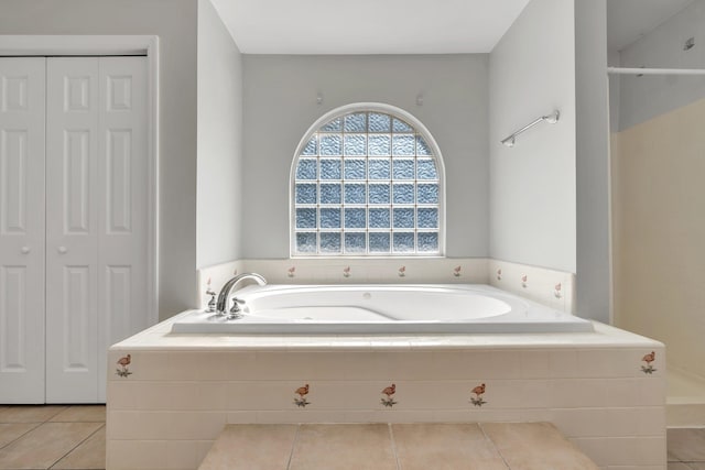 bathroom featuring tile patterned flooring and a relaxing tiled tub