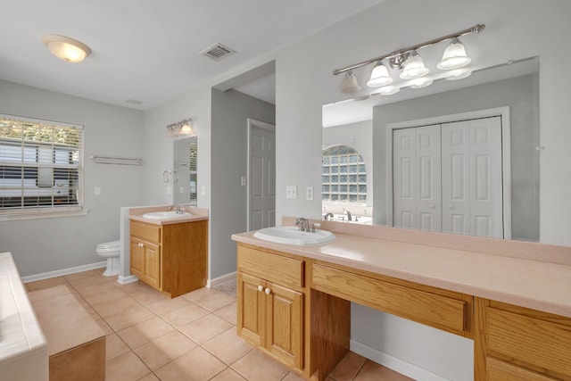 bathroom featuring toilet, vanity, and tile patterned flooring