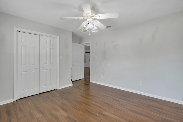 unfurnished bedroom featuring ceiling fan, a closet, and dark wood-type flooring