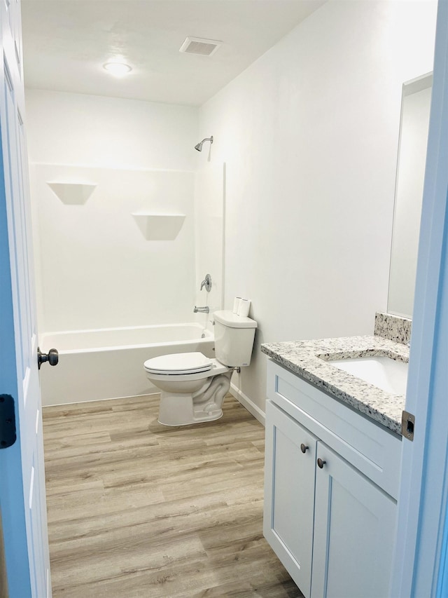 full bathroom featuring wood finished floors, toilet, vanity, and shower / tub combination