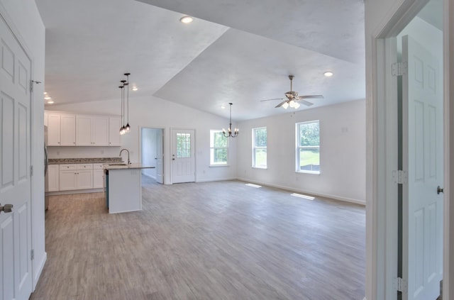 kitchen featuring lofted ceiling, open floor plan, and baseboards