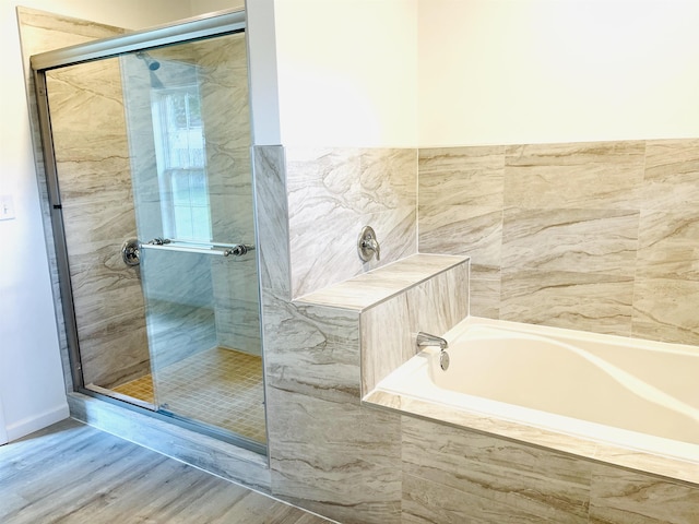 full bathroom featuring a garden tub, wood finished floors, and a shower stall