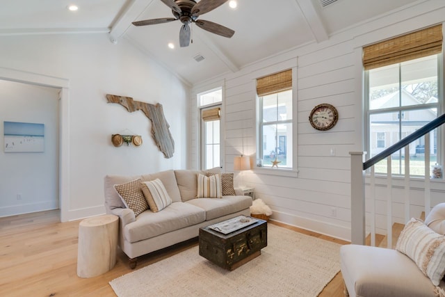 living room featuring wood-type flooring, vaulted ceiling with beams, ceiling fan, and a healthy amount of sunlight