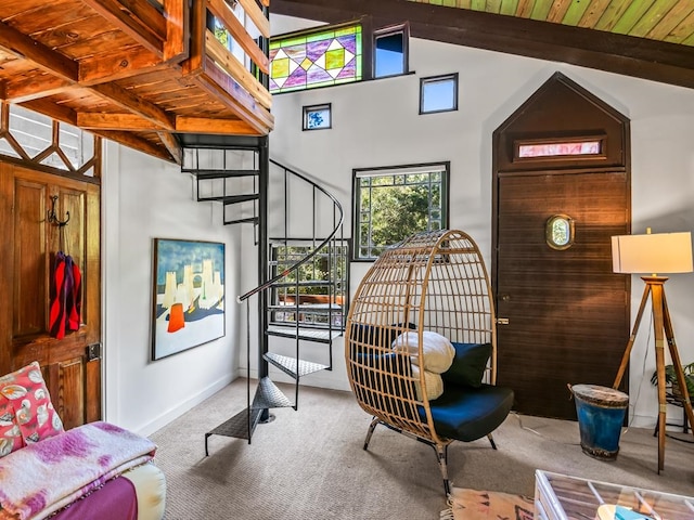 sitting room featuring carpet flooring, vaulted ceiling with beams, and wooden ceiling