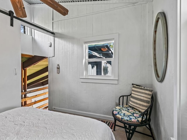 bedroom featuring ceiling fan, a barn door, and lofted ceiling