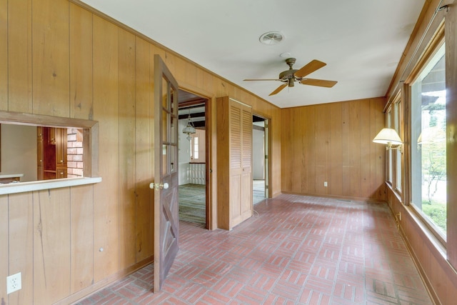 unfurnished sunroom featuring ceiling fan