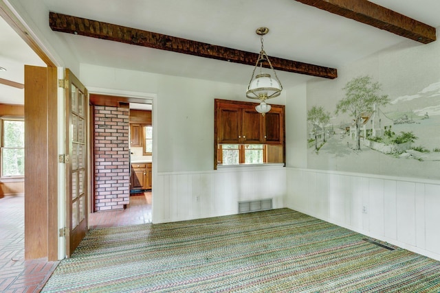 empty room featuring beamed ceiling