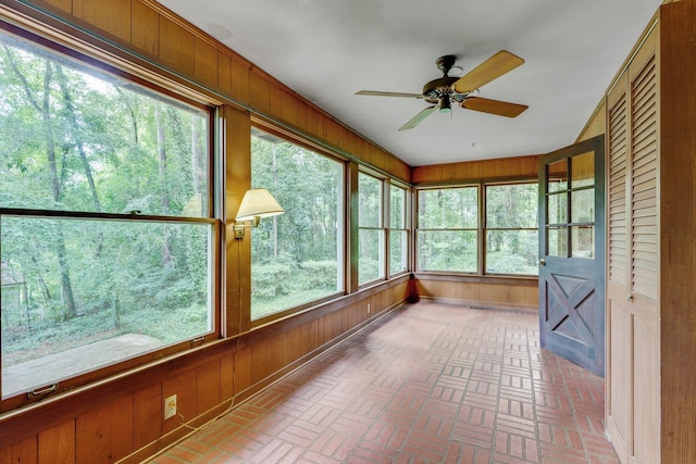 unfurnished sunroom with ceiling fan