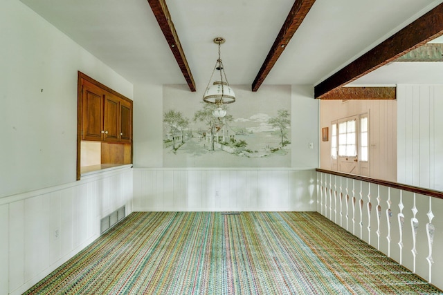 spare room with beamed ceiling and carpet flooring