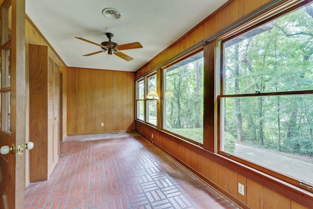 unfurnished sunroom with ceiling fan