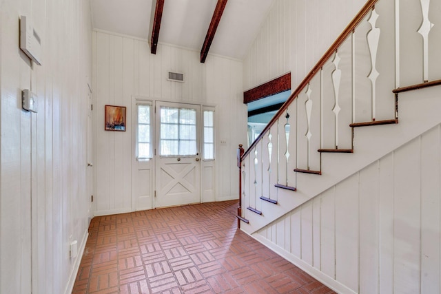 foyer with vaulted ceiling with beams