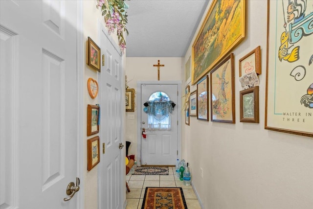 doorway to outside featuring a textured ceiling and light tile patterned flooring