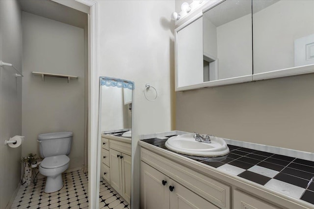 bathroom featuring tile patterned flooring, vanity, and toilet