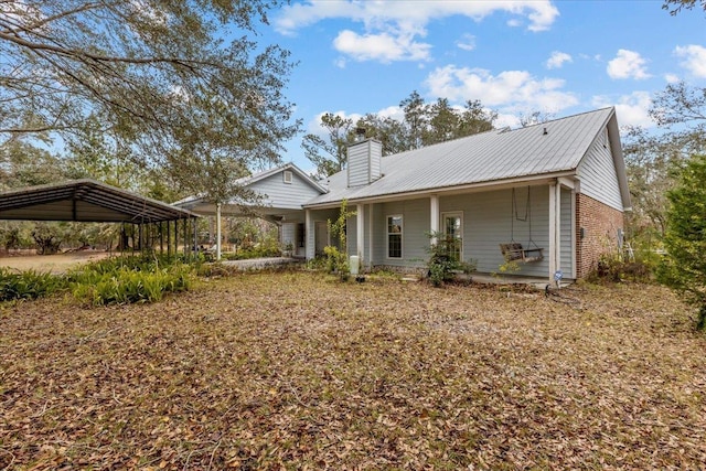 back of property featuring covered porch and a carport