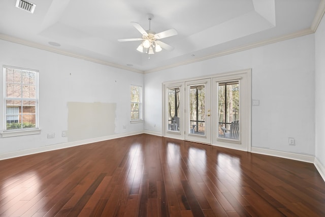 unfurnished room featuring a healthy amount of sunlight, a raised ceiling, and hardwood / wood-style floors