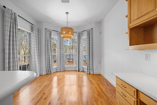 unfurnished dining area featuring light wood-type flooring