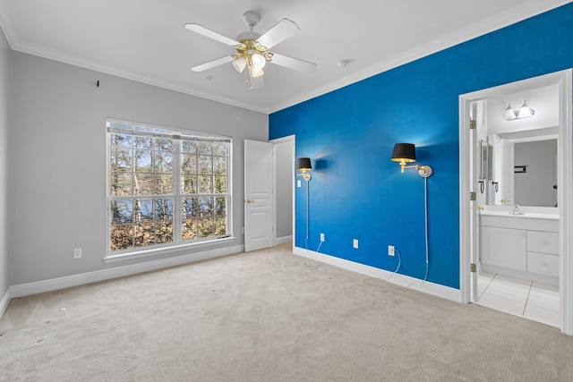 unfurnished bedroom featuring ceiling fan, crown molding, light carpet, ensuite bathroom, and sink