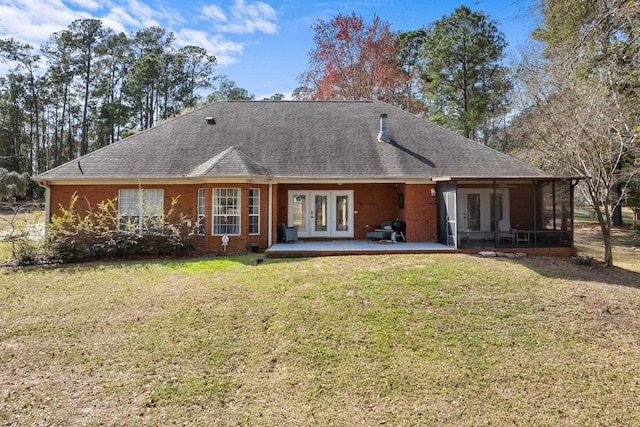 rear view of property featuring french doors, a patio, and a lawn