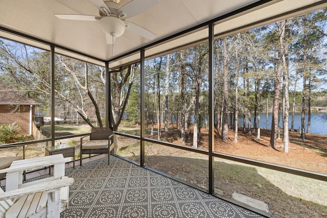 unfurnished sunroom with a water view, ceiling fan, and a healthy amount of sunlight