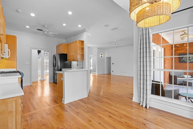 kitchen featuring light hardwood / wood-style floors, pendant lighting, ceiling fan, and sink