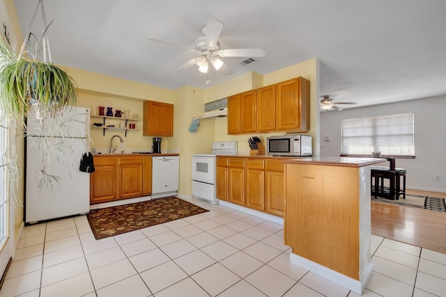 kitchen with kitchen peninsula, sink, light tile patterned flooring, ceiling fan, and white appliances