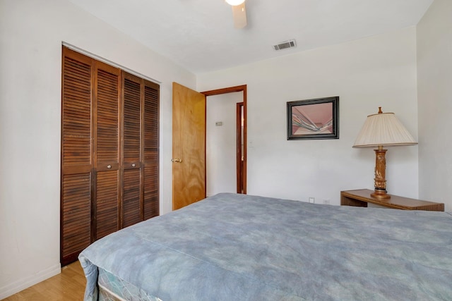 bedroom with light hardwood / wood-style floors, ceiling fan, and a closet