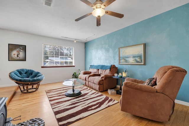 living room with light hardwood / wood-style floors, ceiling fan, and rail lighting