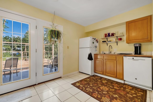 kitchen with white appliances, sink, and light tile patterned floors