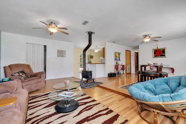 living room with a wood stove and light wood-type flooring