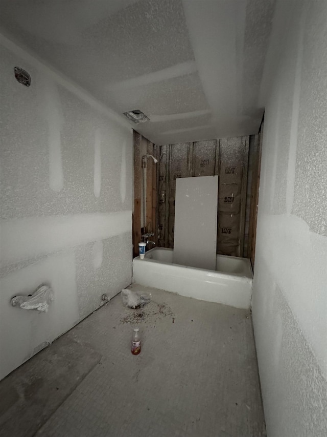 full bathroom with a textured ceiling and a textured wall