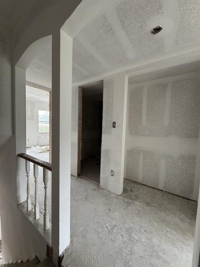 spare room with a textured ceiling and arched walkways