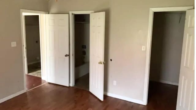 unfurnished bedroom with dark wood-type flooring