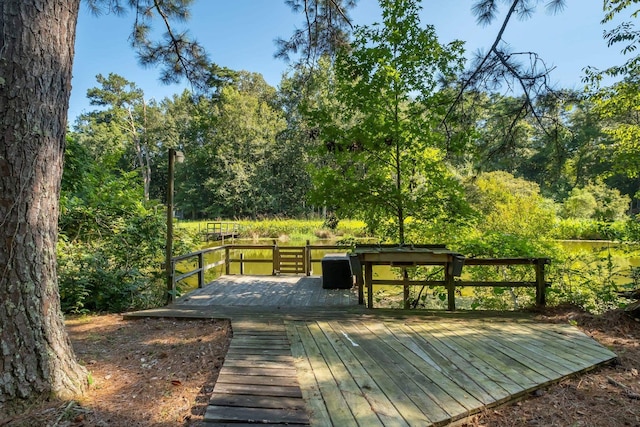view of property's community with a wooded view and a deck