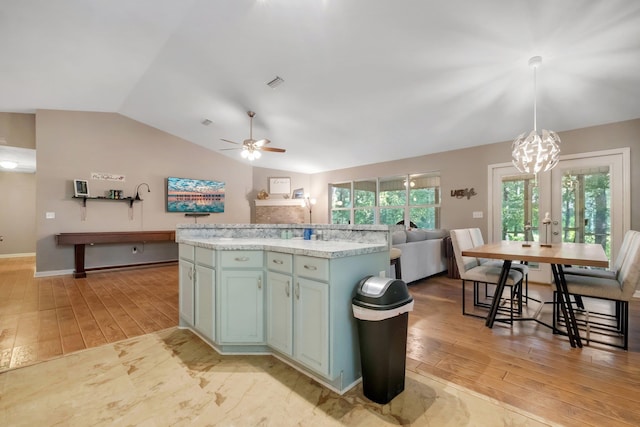kitchen featuring visible vents, vaulted ceiling, light wood-style floors, and ceiling fan with notable chandelier
