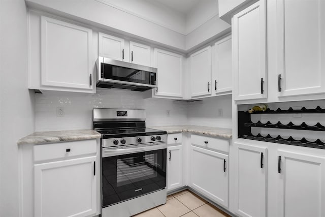 2801 Chancellorsville Dr Unit 1218, Tallahassee, FL 32312 - kitchen featuring stainless steel appliances, light tile patterned floors, white cabinets, and tasteful backsplash