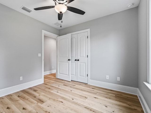 unfurnished bedroom with ceiling fan, a closet, and light wood-type flooring