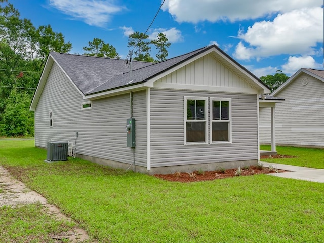 view of side of property with a yard and central air condition unit