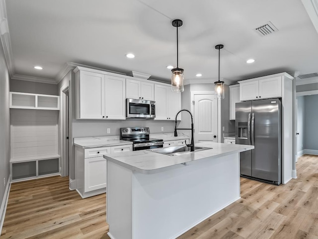 kitchen featuring stainless steel appliances, white cabinetry, sink, and decorative light fixtures