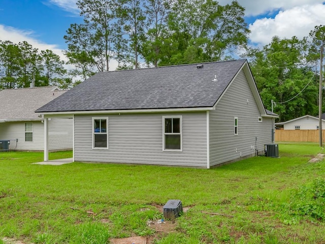 rear view of house featuring a yard and central air condition unit