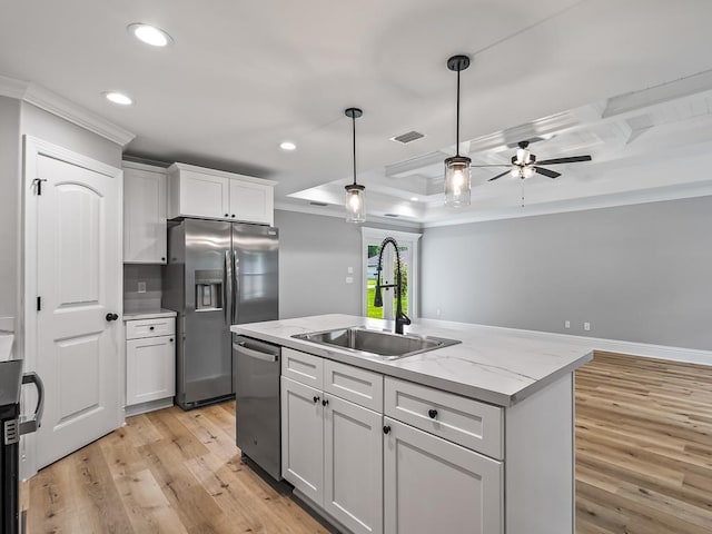 kitchen with sink, stainless steel appliances, light stone countertops, an island with sink, and white cabinets