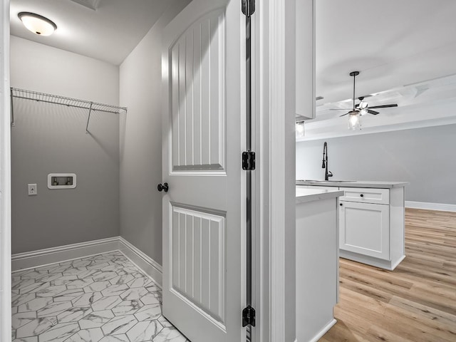 washroom with ceiling fan, sink, washer hookup, and light hardwood / wood-style floors