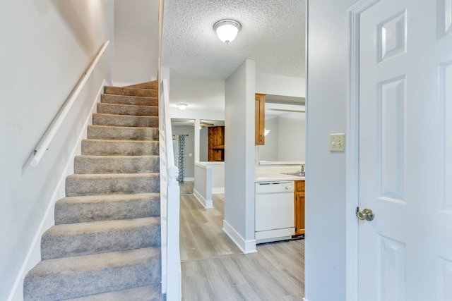 stairs with hardwood / wood-style flooring and a textured ceiling