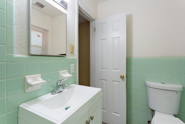 1318 W Tharpe St, Tallahassee, FL 32303 - bathroom with tile walls, vanity, toilet, and wainscoting