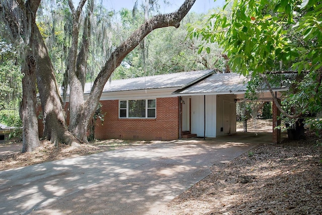 1318 W Tharpe St, Tallahassee, FL 32303 - view of front of property with crawl space, driveway, brick siding, a carport, and metal roof