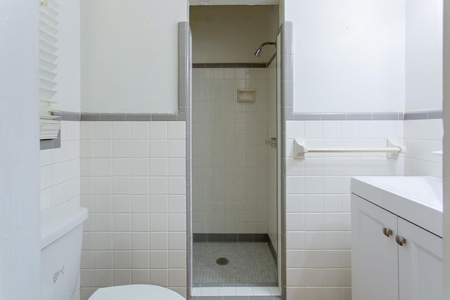 1318 W Tharpe St, Tallahassee, FL 32303 - bathroom featuring tile walls, a stall shower, toilet, vanity, and a wainscoted wall