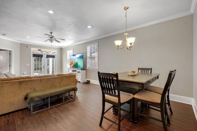 dining room featuring ornamental molding, ceiling fan with notable chandelier, french doors, and dark wood-type flooring